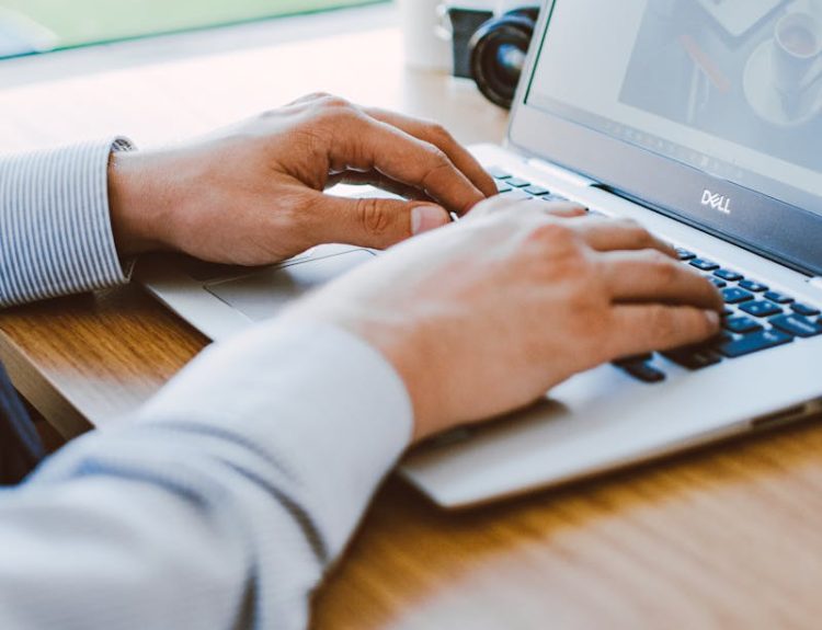 Man Using Dell Laptop to optimize the chamber of commerce seo
