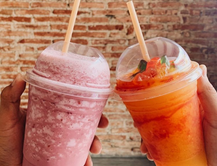 people holding cups of smoothie