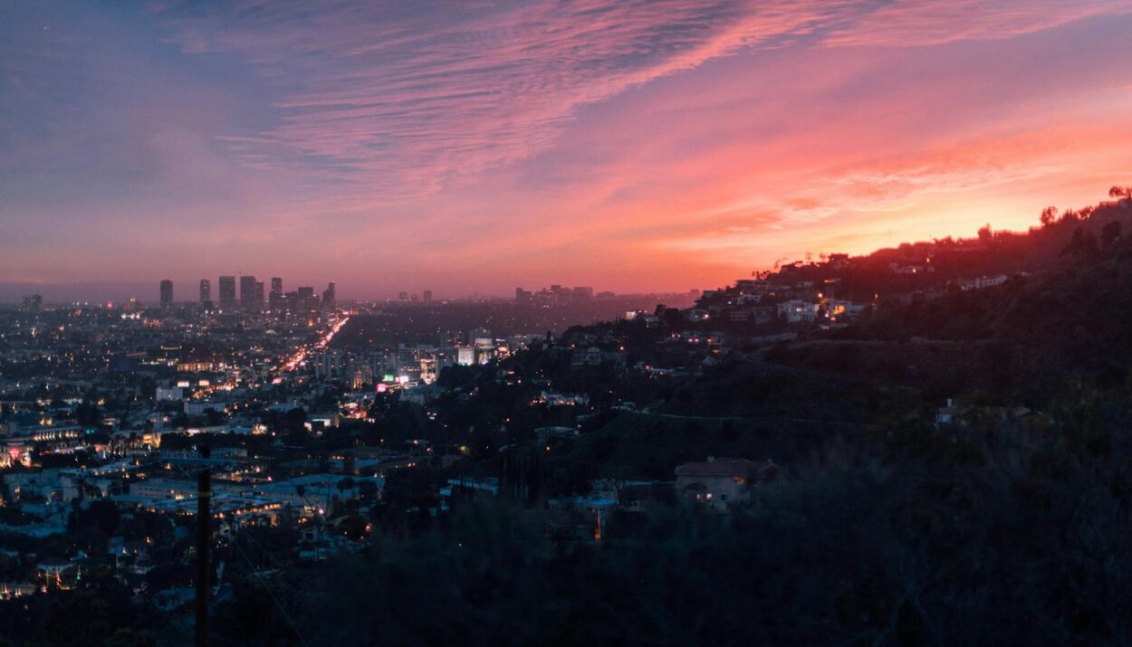 Capture of the vibrant Los Angeles skyline under a dramatic sunset sky.