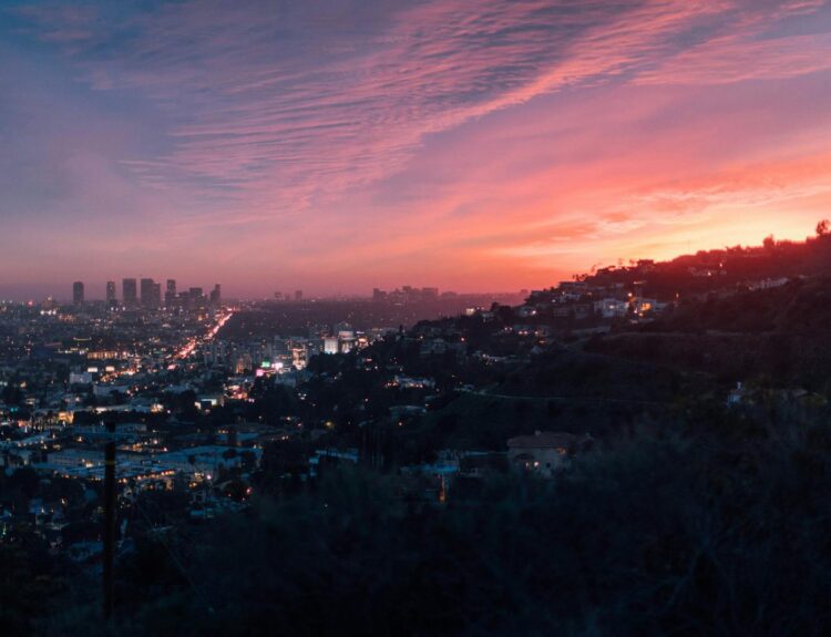 Capture of the vibrant Los Angeles skyline under a dramatic sunset sky.