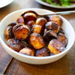 selective focus photography of glazed nuts inside white ceramic saucer