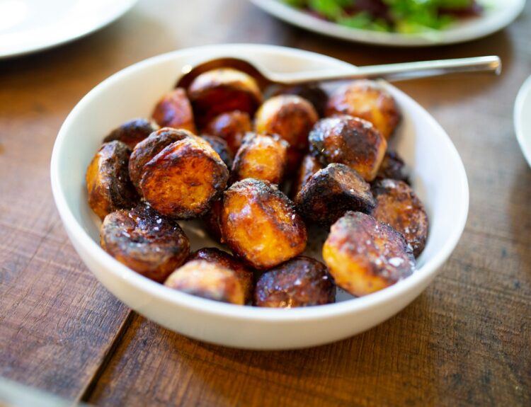 selective focus photography of glazed nuts inside white ceramic saucer